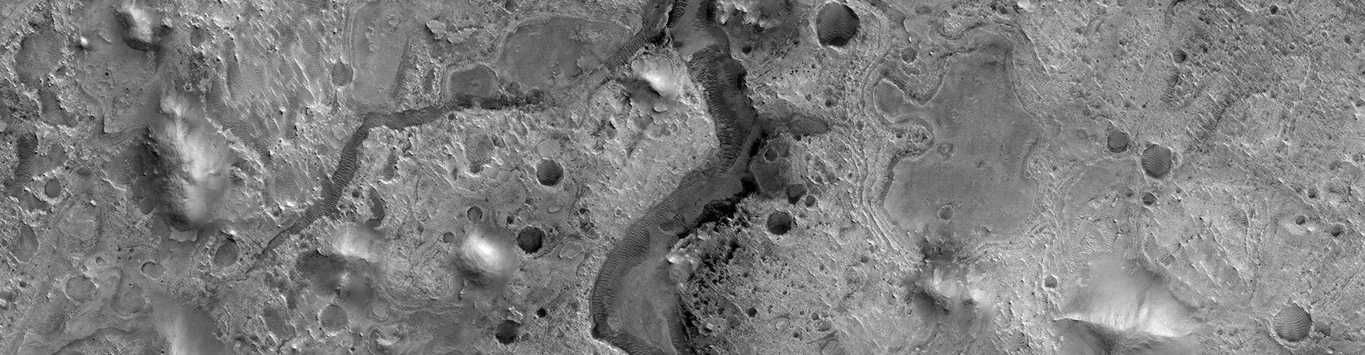 Orbital view of Martian terrain: valleys, craters and sedimentary deposits.